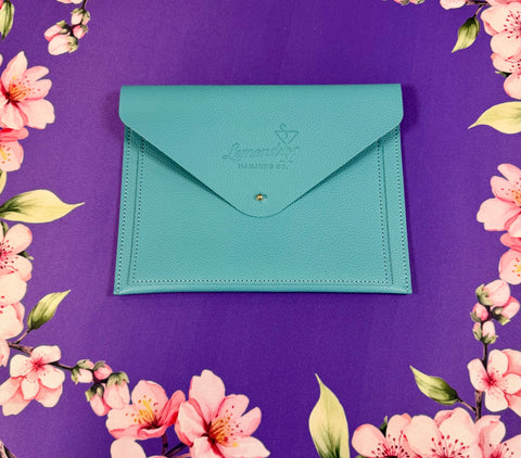 a blue envelope on a purple surface with pink flowers