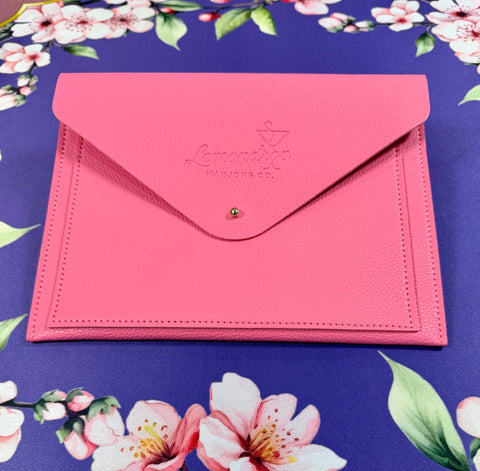 a pink envelope on a floral surface