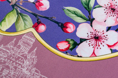 Floral print fabric featuring pink cherry blossoms on a purple background with golden trim.