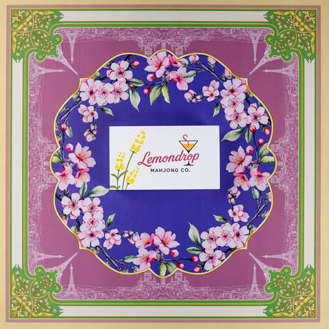 Lemondrop Mahjong Co. floral-themed game mat with vibrant purple and green design featuring cherry blossoms.