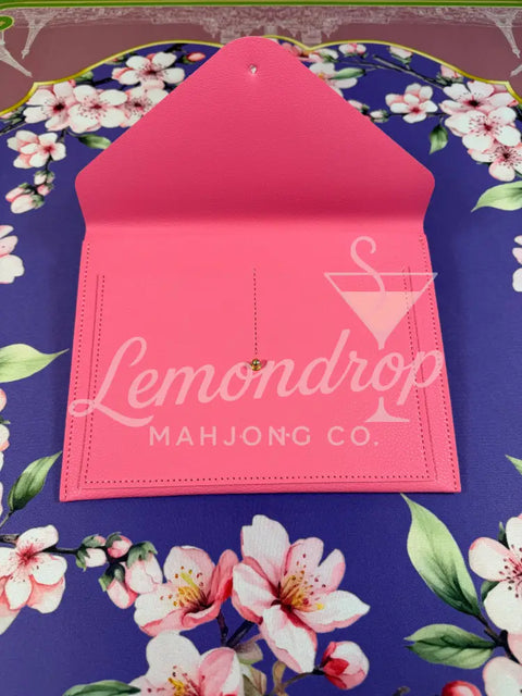 a pink envelope on a floral surface