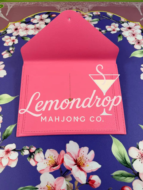 a pink envelope on a floral surface