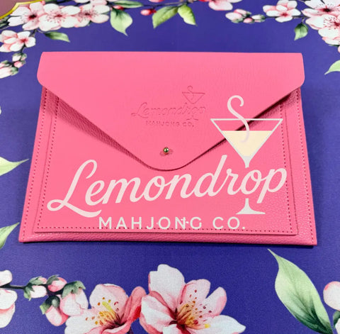 a pink envelope on a floral surface