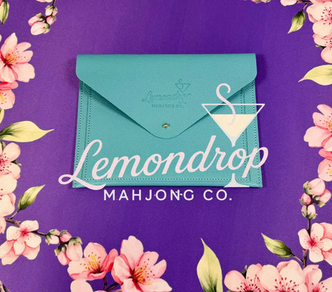a blue envelope on a purple surface with pink flowers