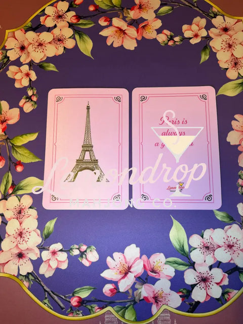 two plastic shufflers, one featuring an image of the Eiffel Tower while the other side says Paris is always a good idea 